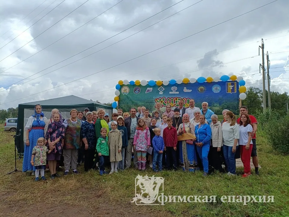 Жители деревни Карпово и духовенство на празднике-фестивале на фоне баннера «Живи, Деревня»